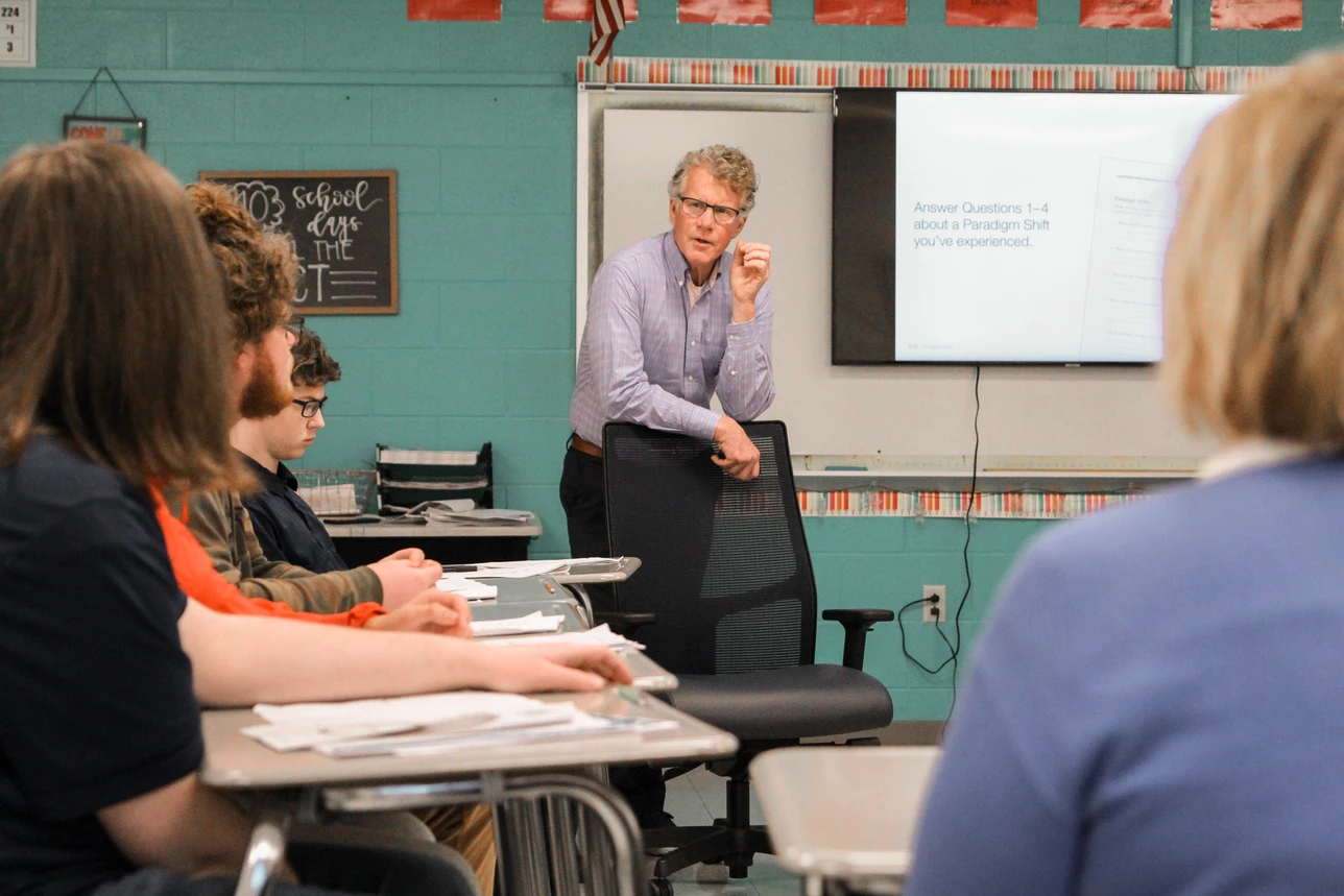 An educator guiding students through a classroom discussion